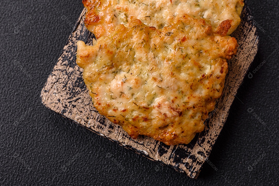 Deliciosas costeletas de porco ou frango fritas à milanesa com sal e especiarias sobre um fundo escuro de concreto