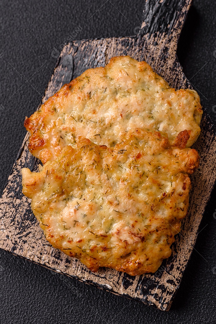 Deliciosas costeletas de porco ou frango fritas à milanesa com sal e especiarias sobre um fundo escuro de concreto