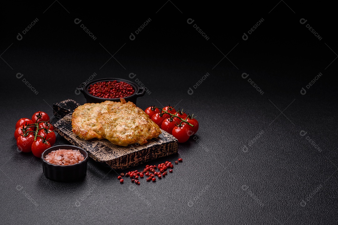 Deliciosas costeletas de porco ou frango fritas à milanesa com sal e especiarias sobre um fundo escuro de concreto