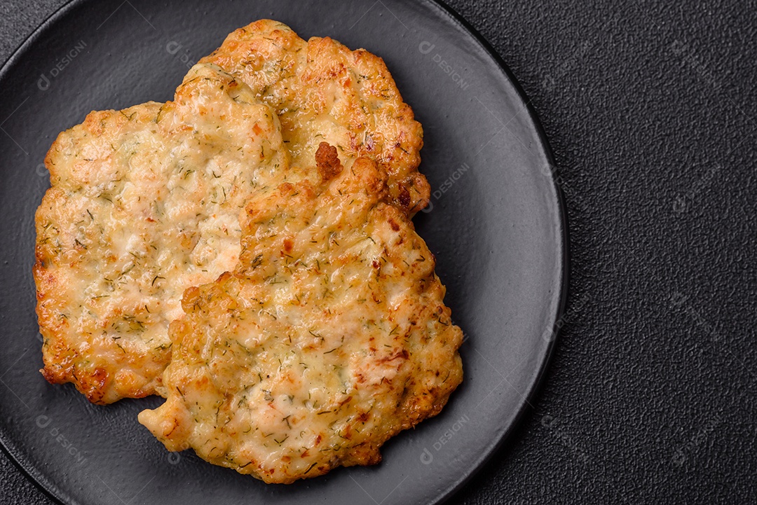 Deliciosas costeletas de porco ou frango fritas à milanesa com sal e especiarias sobre um fundo escuro de concreto