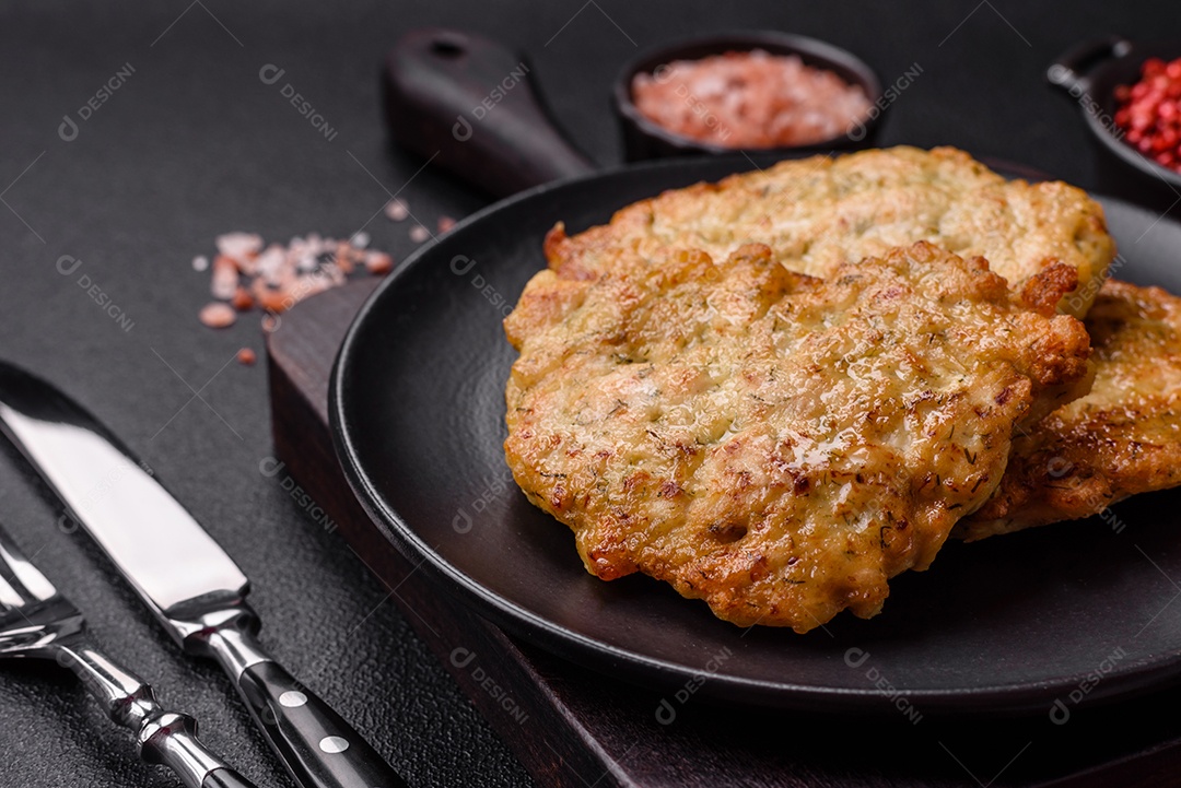Deliciosas costeletas de porco ou frango fritas à milanesa com sal e especiarias sobre um fundo escuro de concreto