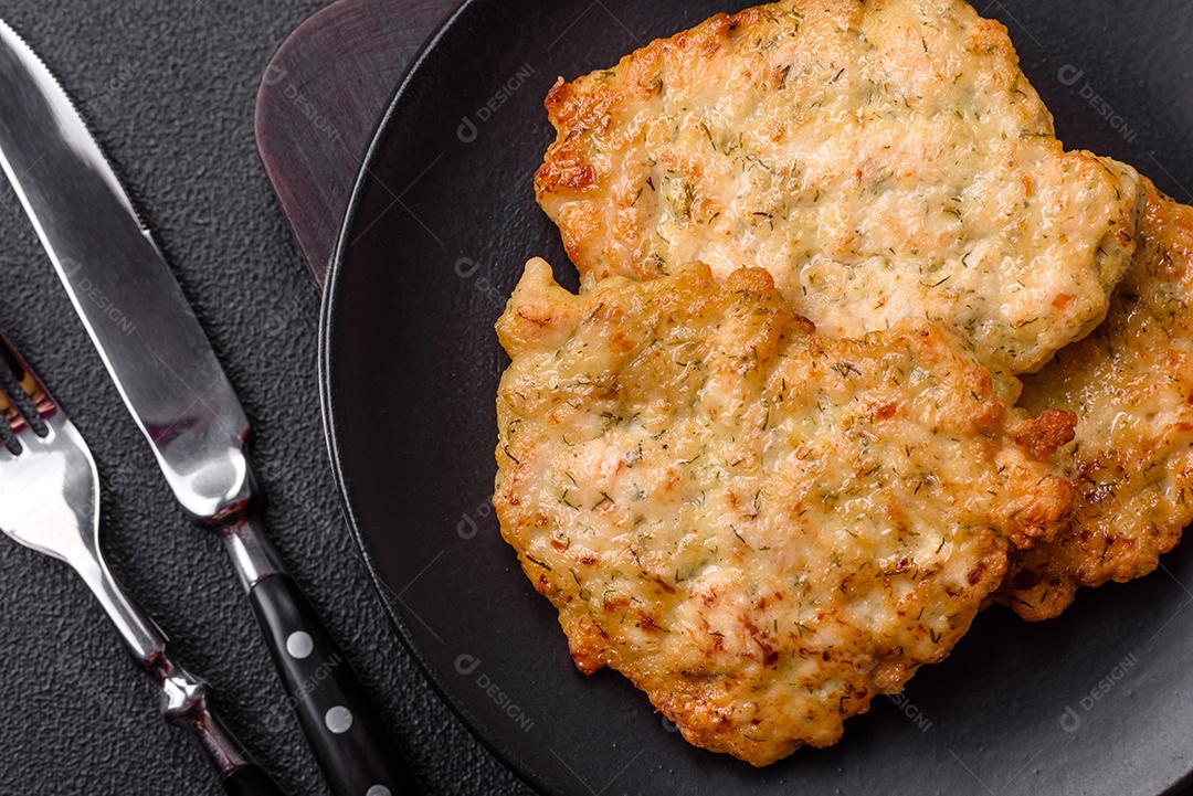 Deliciosas costeletas de porco ou frango fritas à milanesa com sal e especiarias sobre um fundo escuro de concreto