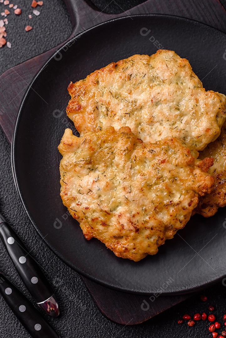 Deliciosas costeletas de porco ou frango fritas à milanesa com sal e especiarias sobre um fundo escuro de concreto