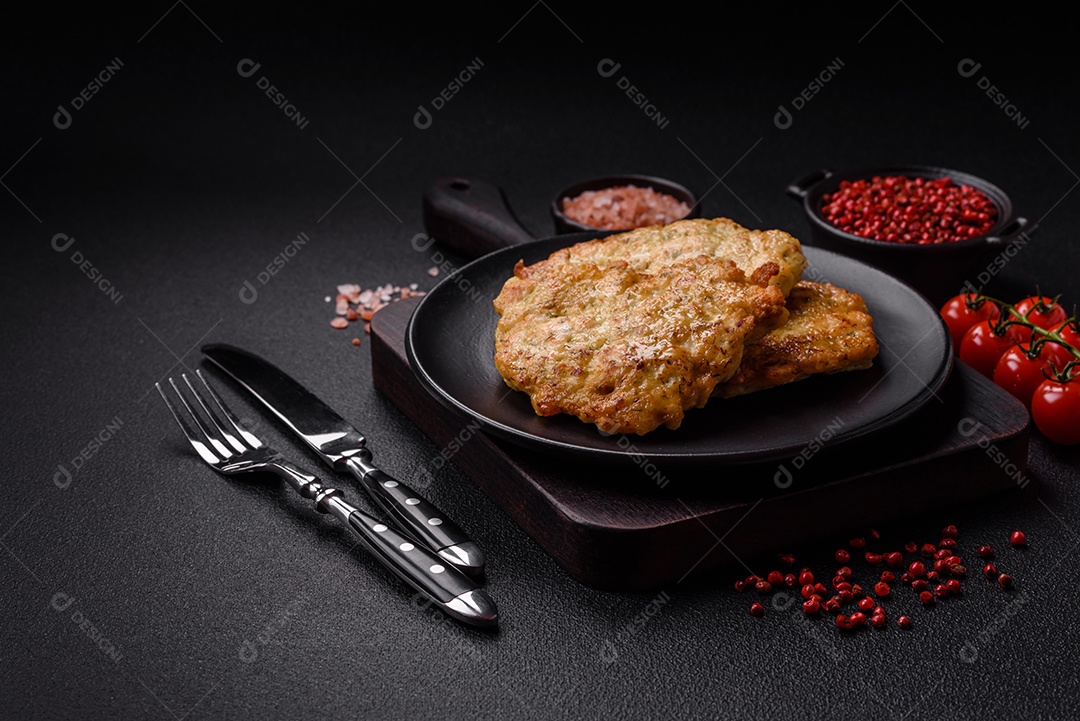 Deliciosas costeletas de porco ou frango fritas à milanesa com sal e especiarias sobre um fundo escuro de concreto