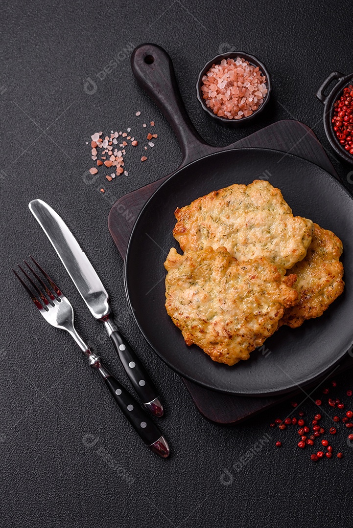 Deliciosas costeletas de porco ou frango fritas à milanesa com sal e especiarias sobre um fundo escuro de concreto