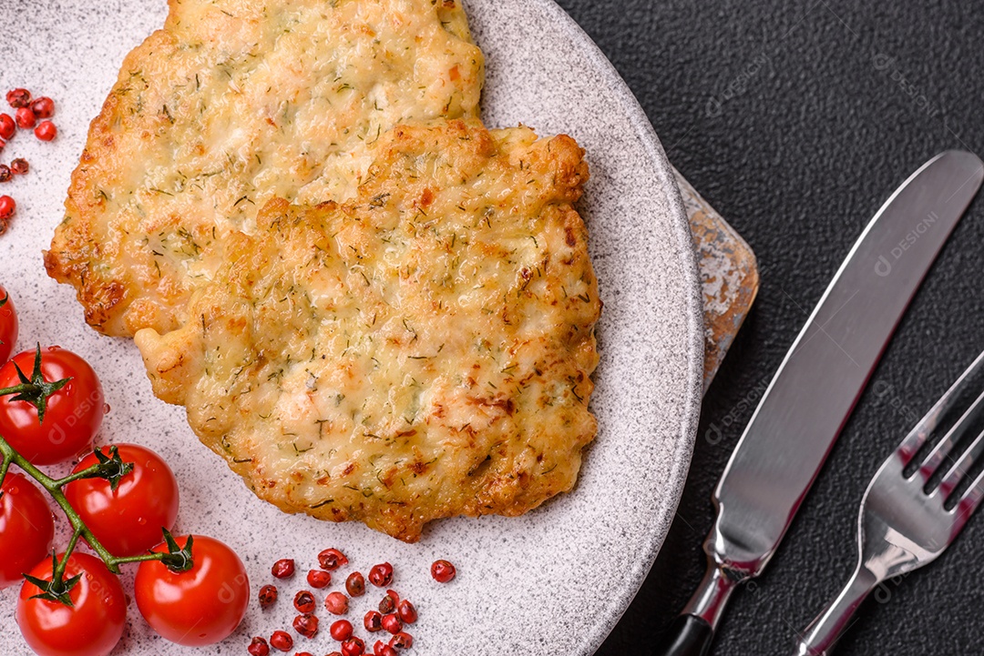 Deliciosas costeletas de porco ou frango fritas à milanesa com sal e especiarias sobre um fundo escuro de concreto