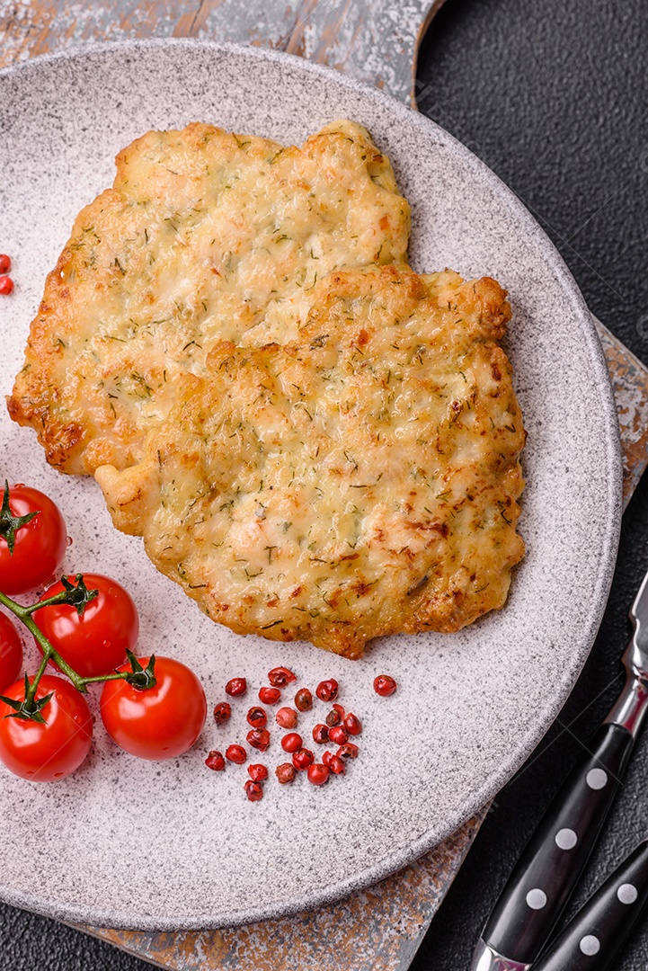 Deliciosas costeletas de porco ou frango fritas à milanesa com sal e especiarias sobre um fundo escuro de concreto