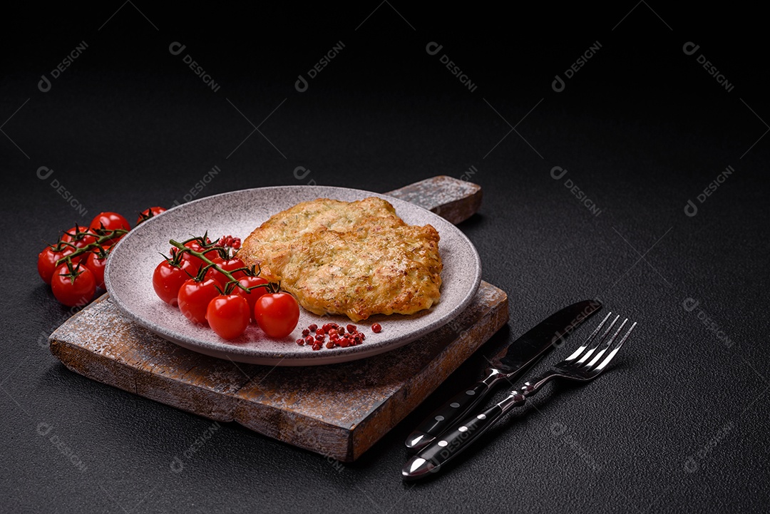 Deliciosas costeletas de porco ou frango fritas à milanesa com sal e especiarias sobre um fundo escuro de concreto