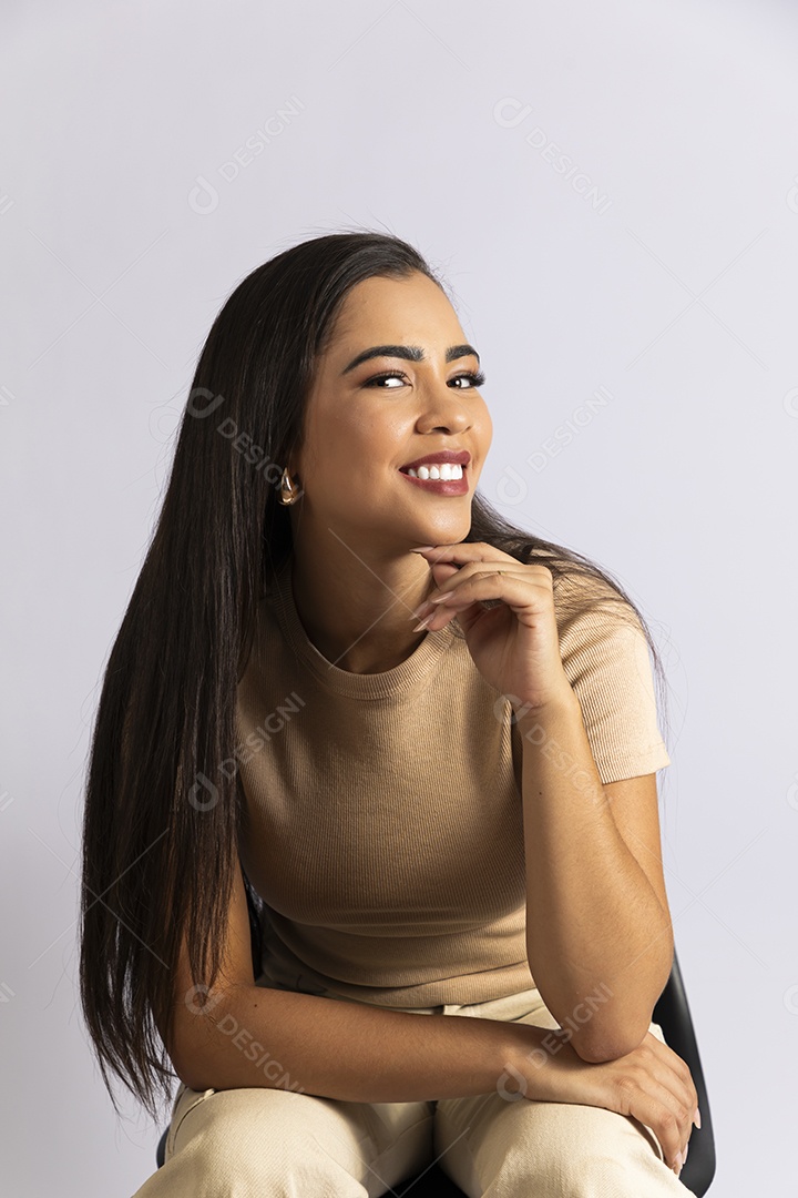 Jovem mulher sorrindo e com pose de mão no queixo