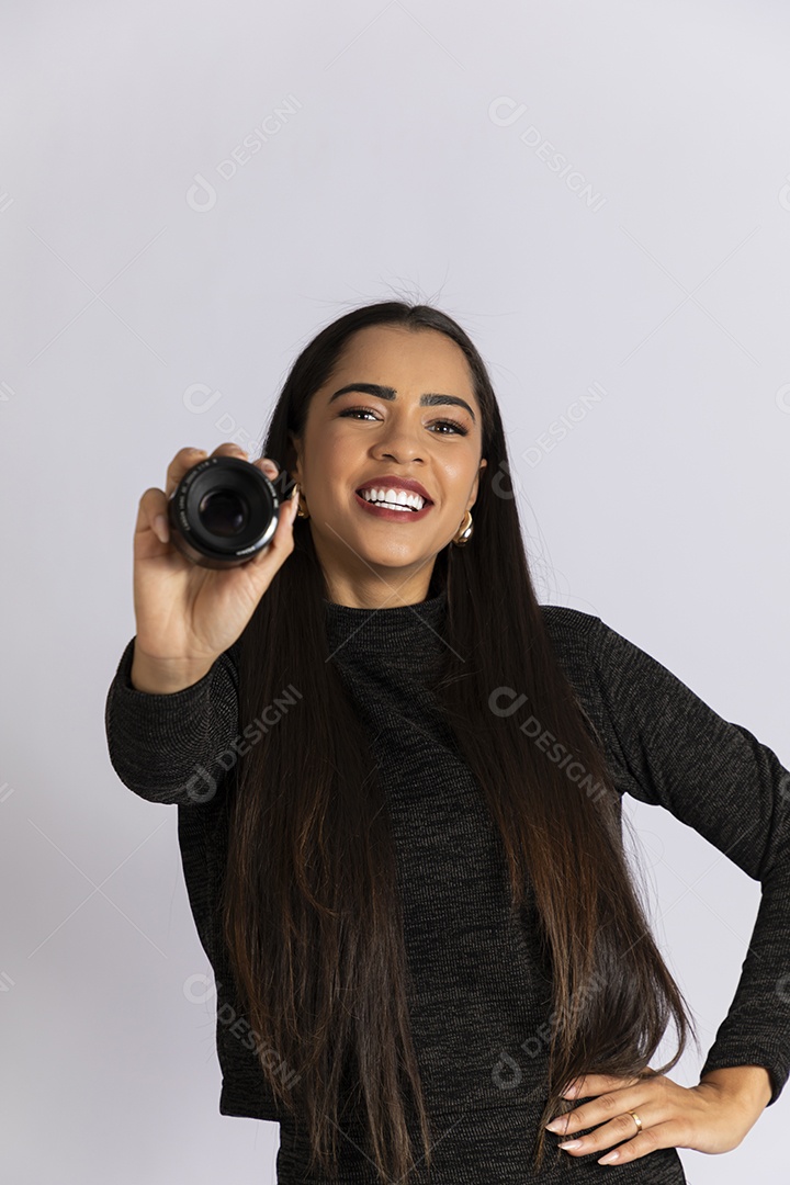Jovem linda sorrindo e com lentes de camera nas mãos