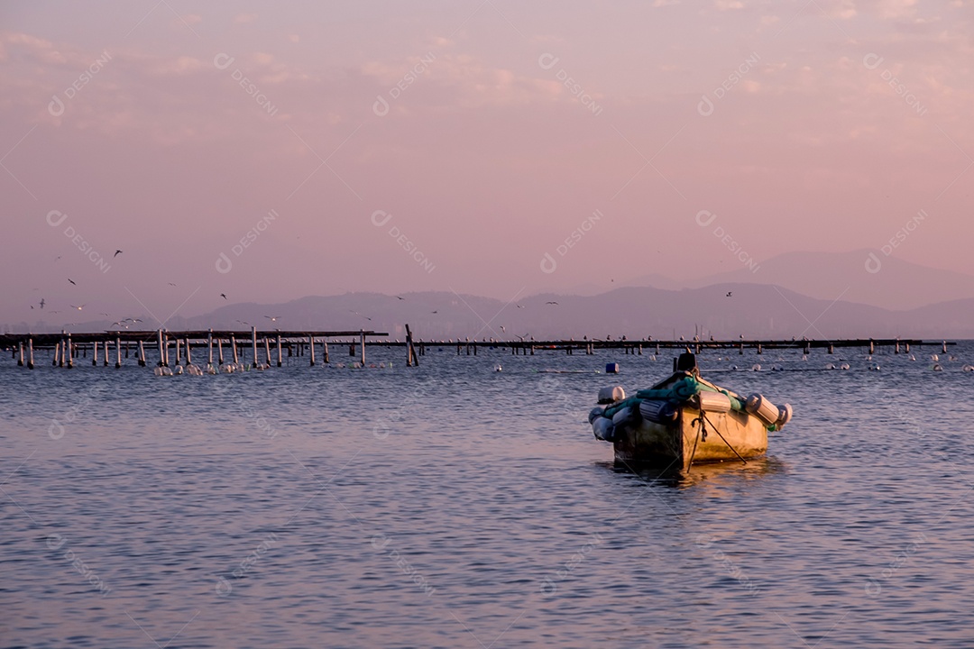 Pôr do sol no mar canoa com montanhas ao fundo