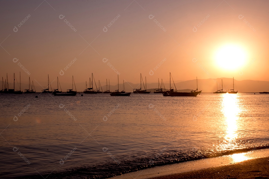 Pôr do sol com barcos em silhueta