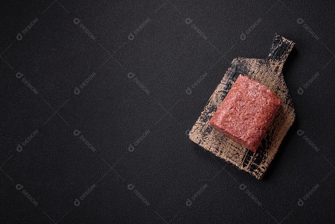 Delicioso presunto rosa enlatado com sal, especiarias e ervas sobre um fundo escuro de concreto