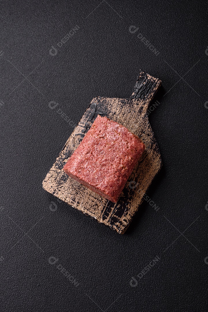 Delicioso presunto rosa enlatado com sal, especiarias e ervas sobre um fundo escuro de concreto