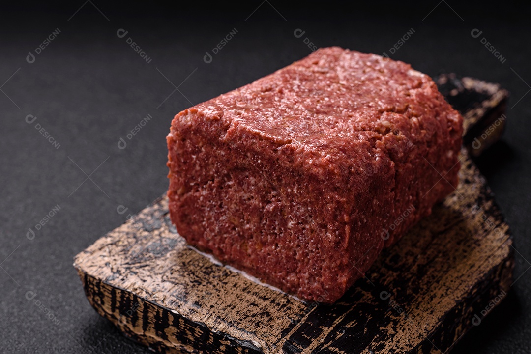 Delicioso presunto rosa enlatado com sal, especiarias e ervas sobre um fundo escuro de concreto