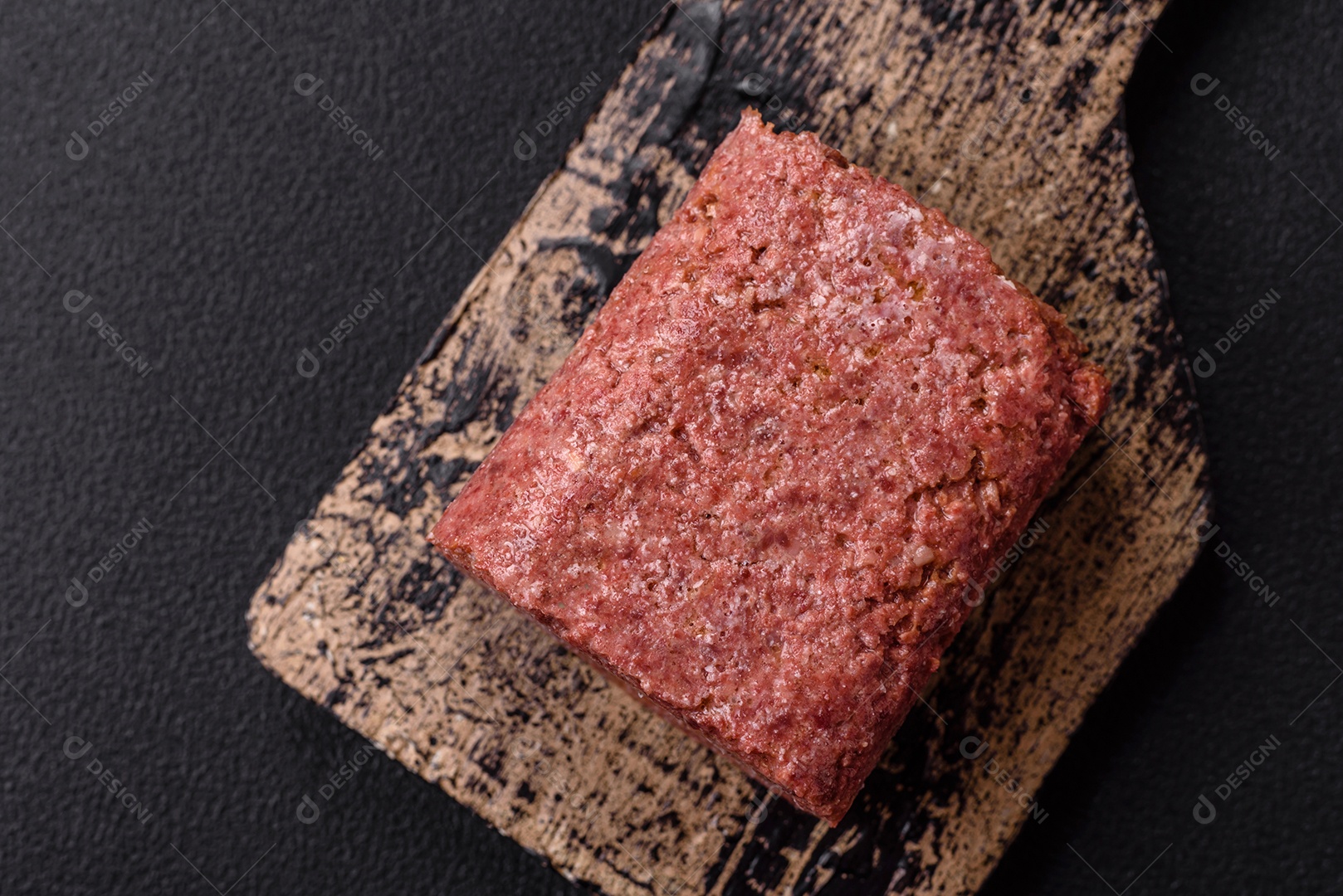 Delicioso presunto rosa enlatado com sal, especiarias e ervas sobre um fundo escuro de concreto