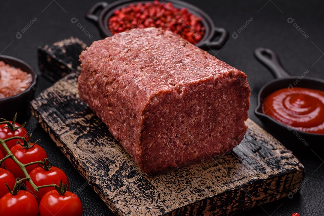 Delicioso presunto rosa enlatado com sal, especiarias e ervas sobre um fundo escuro de concreto