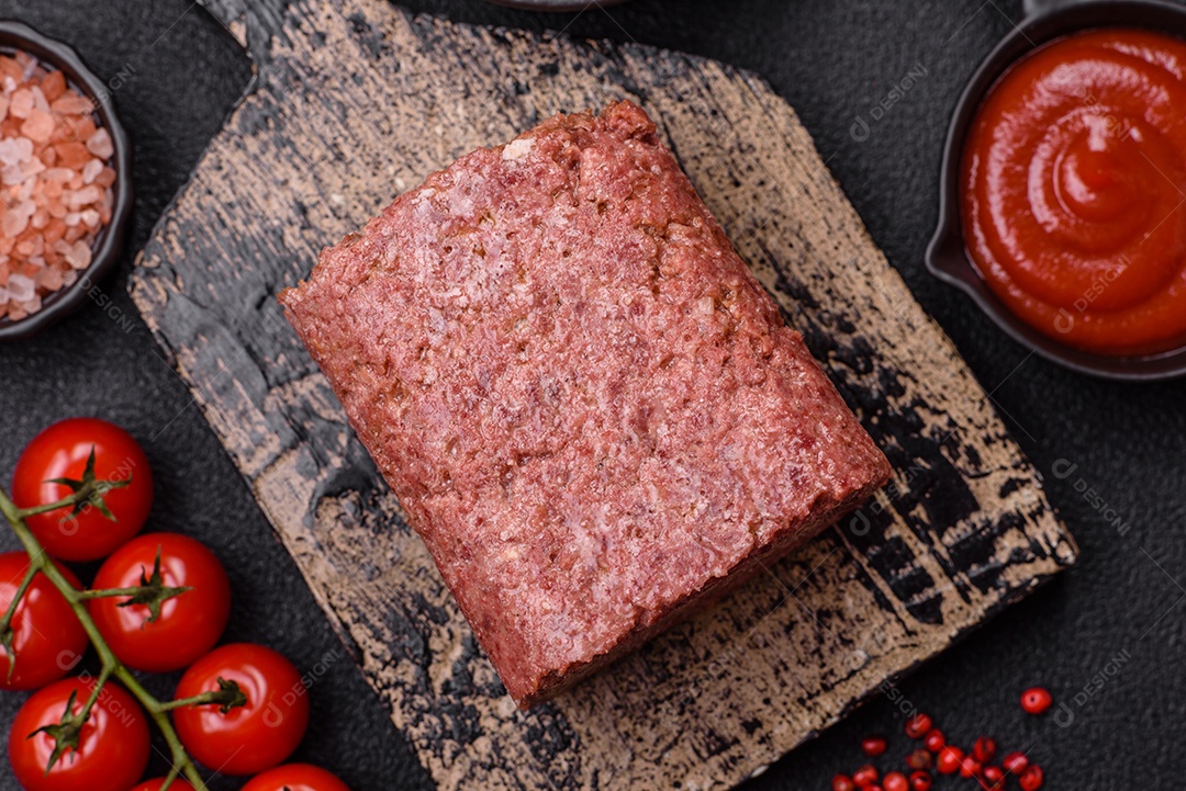Delicioso presunto rosa enlatado com sal, especiarias e ervas sobre um fundo escuro de concreto