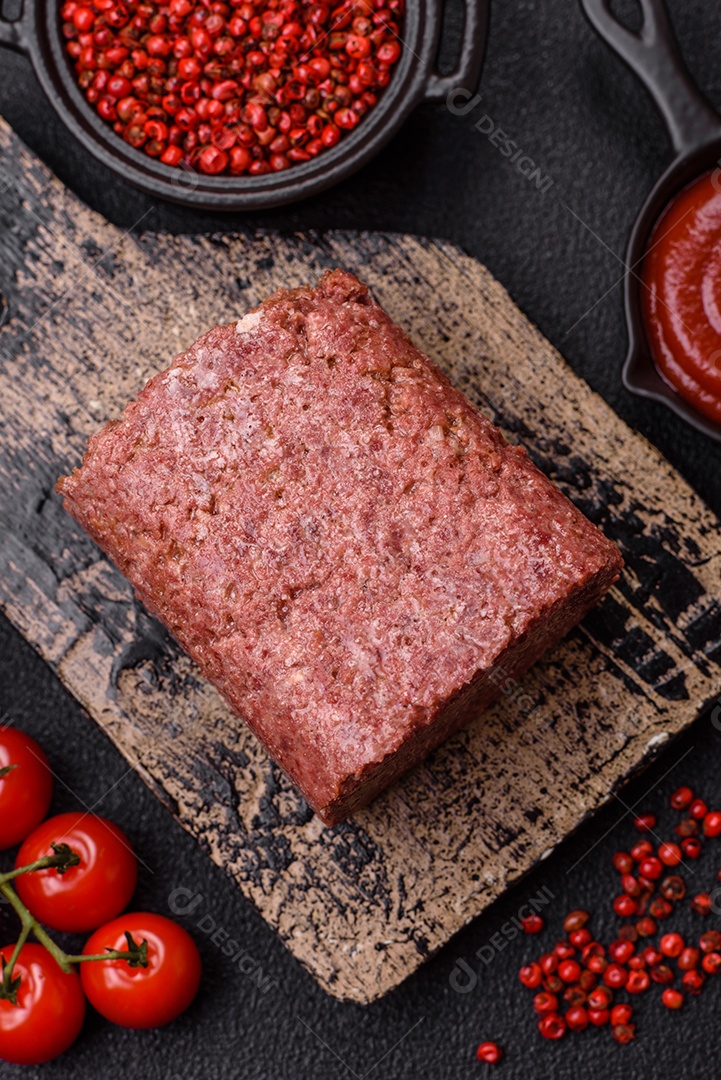 Delicioso presunto rosa enlatado com sal, especiarias e ervas sobre um fundo escuro de concreto