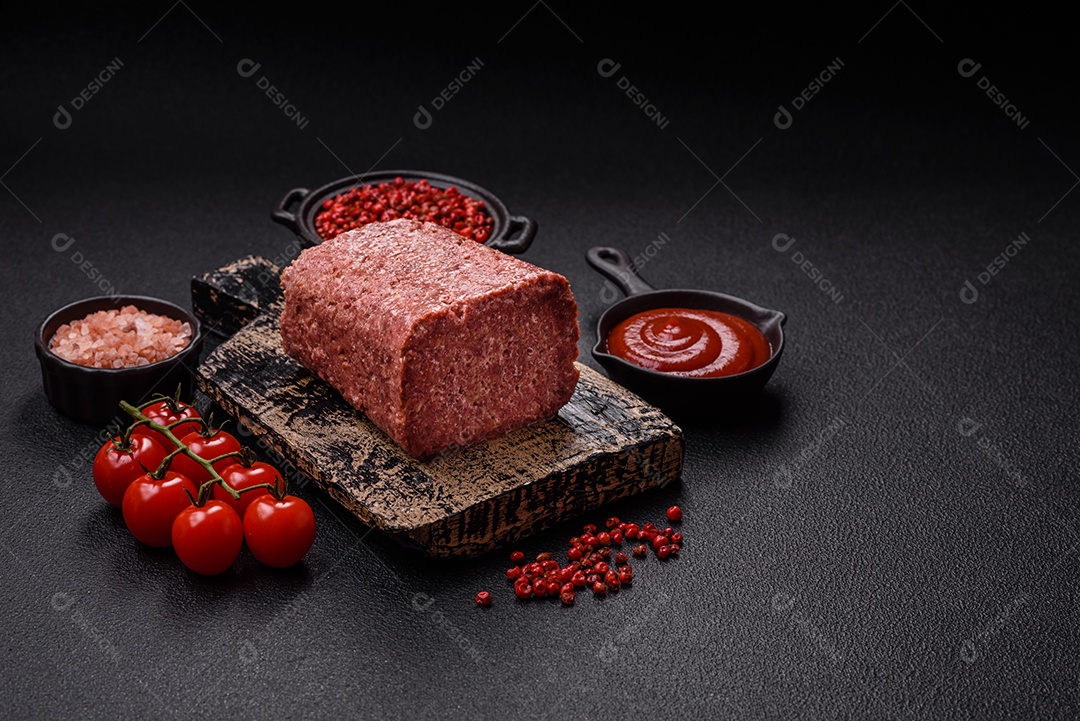 Delicioso presunto rosa enlatado com sal, especiarias e ervas sobre um fundo escuro de concreto