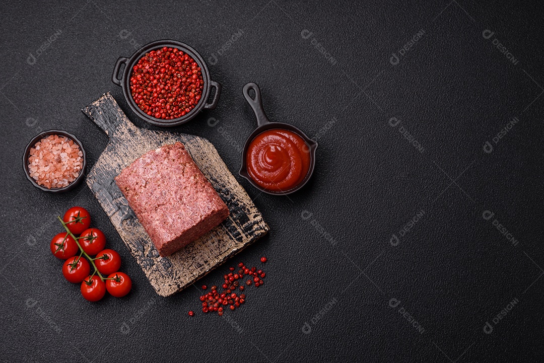 Delicioso presunto rosa enlatado com sal, especiarias e ervas sobre um fundo escuro de concreto