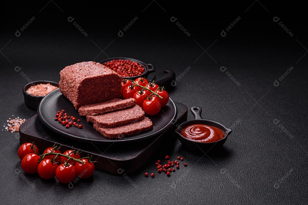 Delicioso presunto rosa enlatado com sal, especiarias e ervas sobre um fundo escuro de concreto