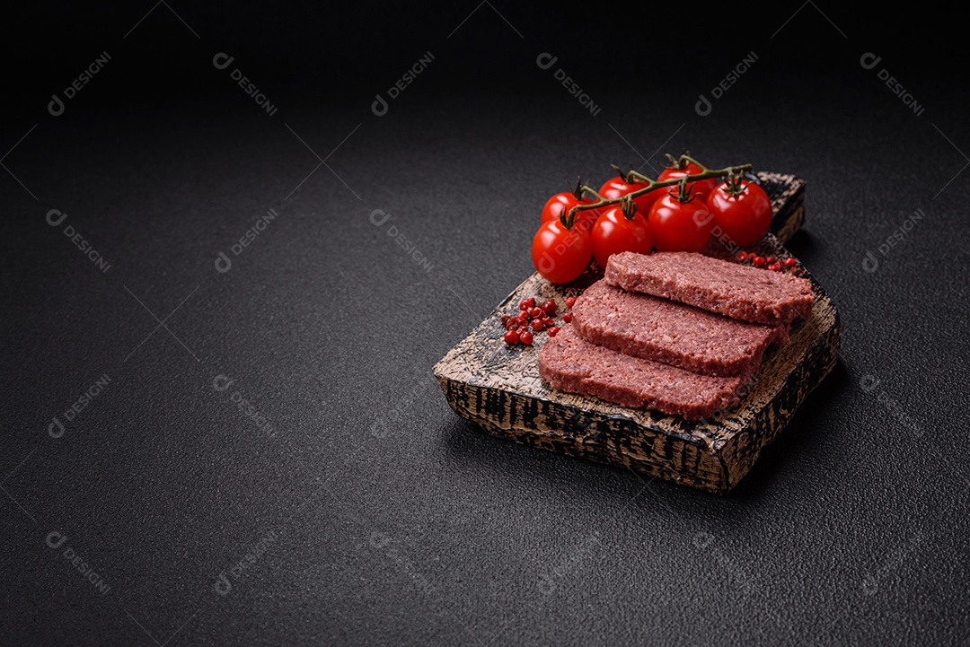 Delicioso presunto rosa enlatado com sal, especiarias e ervas sobre um fundo escuro de concreto