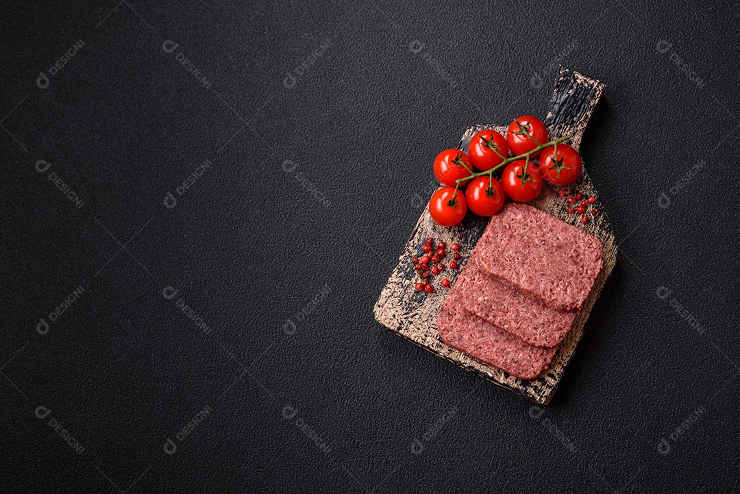 Delicioso presunto rosa enlatado com sal, especiarias e ervas sobre um fundo escuro de concret