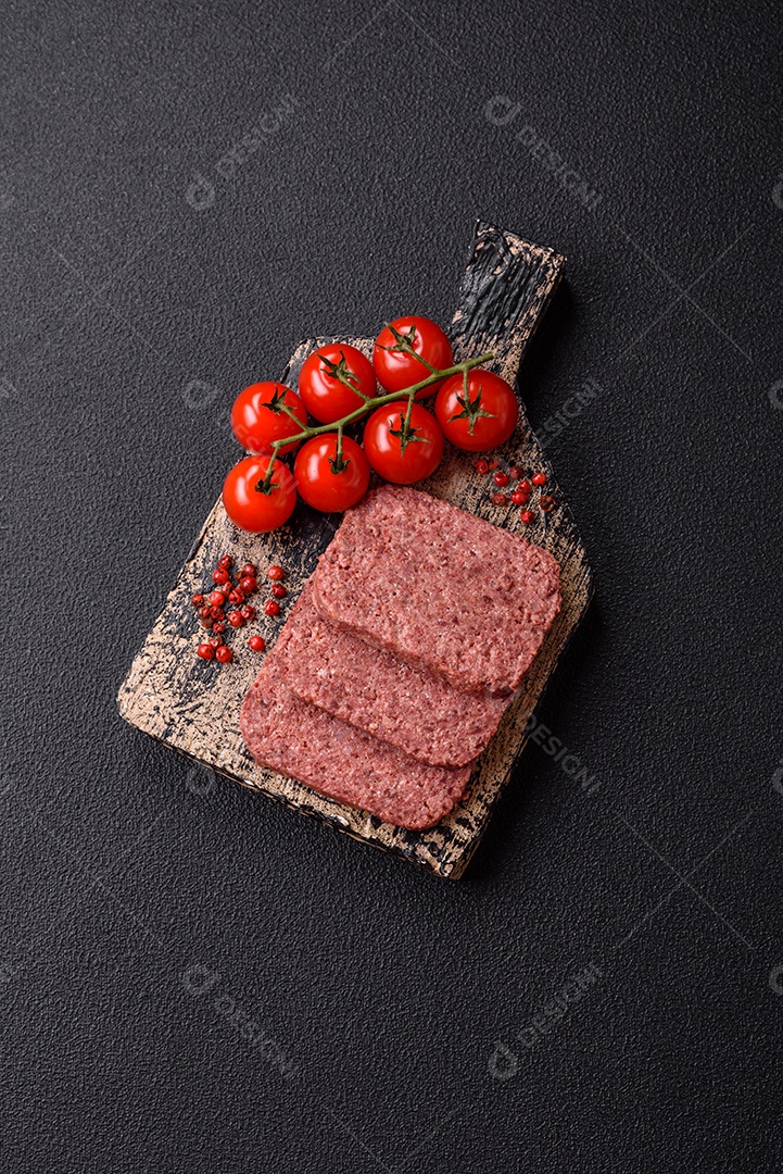 Delicioso presunto rosa enlatado com sal, especiarias e ervas sobre um fundo escuro de concreto