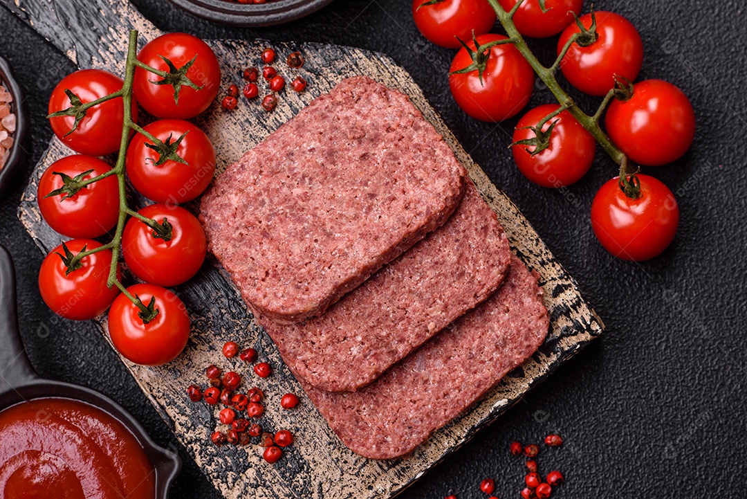 Delicioso presunto rosa enlatado com sal, especiarias e ervas sobre um fundo escuro de concreto