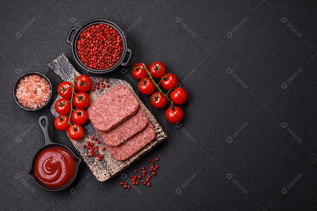 Delicioso presunto rosa enlatado com sal, especiarias e ervas sobre um fundo escuro de concreto