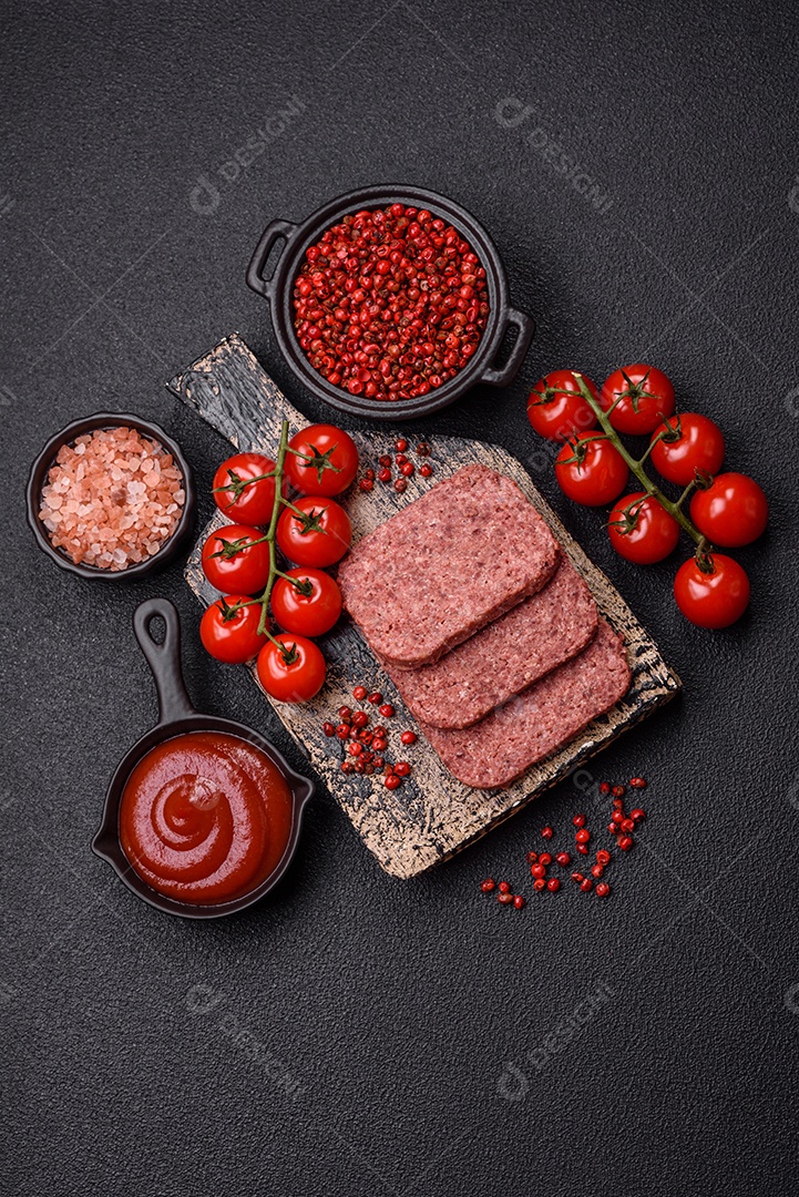 Delicioso presunto rosa enlatado com sal, especiarias e ervas sobre um fundo escuro de concreto