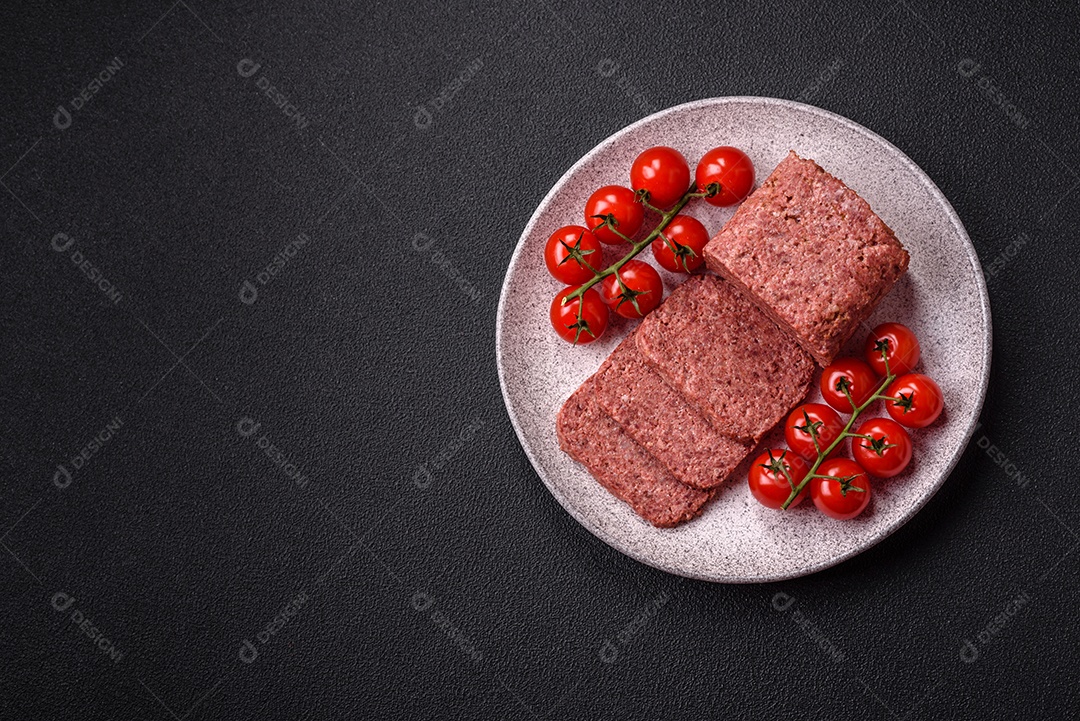 Delicioso presunto rosa enlatado com sal, especiarias e ervas sobre um fundo escuro de concreto