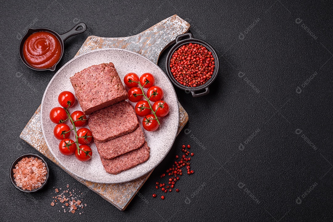 Delicioso presunto rosa enlatado com sal, especiarias e ervas sobre um fundo escuro de concreto