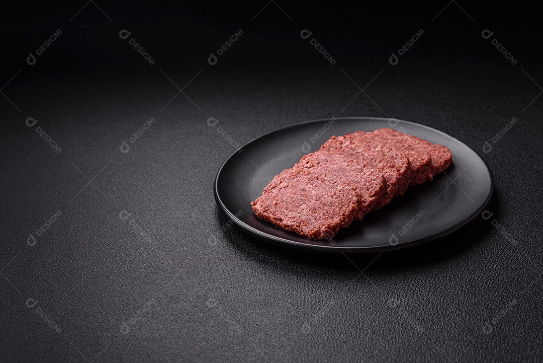 Delicioso presunto rosa enlatado com sal, especiarias e ervas sobre um fundo escuro de concreto