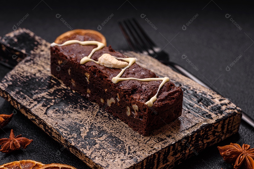 Deliciosos brownies doces com chocolate e nozes em um fundo escuro de concreto