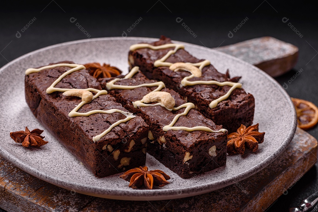 Deliciosos brownies doces com chocolate e nozes em um fundo escuro de concreto
