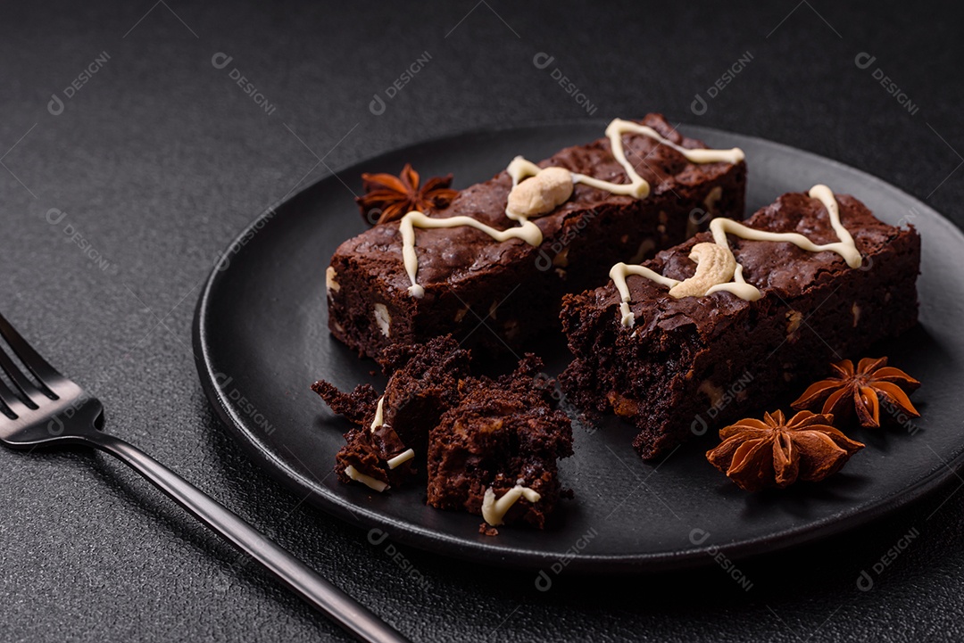 Deliciosos brownies doces com chocolate e nozes em um fundo escuro de concreto