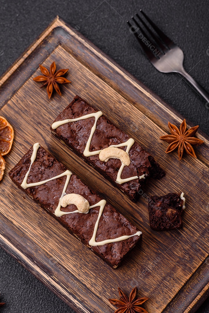 Deliciosos brownies doces com chocolate e nozes em um fundo escuro de concreto