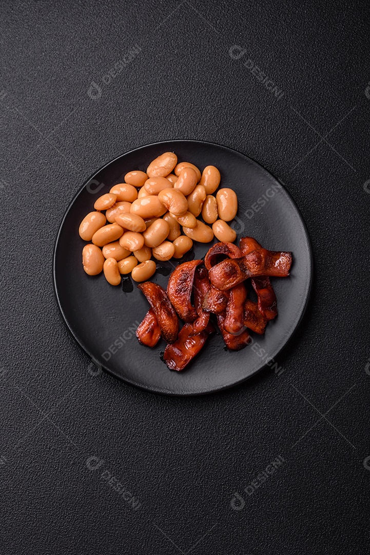 Delicioso feijão enlatado nutritivo com tomate, com sal e temperos como complemento de alto teor calórico para o café da manhã