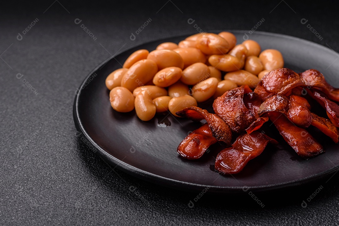 Delicioso feijão enlatado nutritivo com tomate, com sal e temperos como complemento de alto teor calórico para o café da manhã