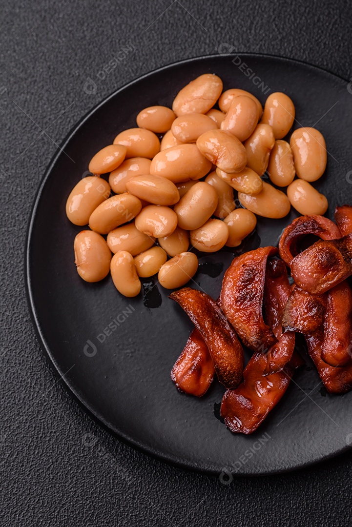 Delicioso feijão enlatado nutritivo com tomate, com sal e temperos como complemento de alto teor calórico para o café da manhã