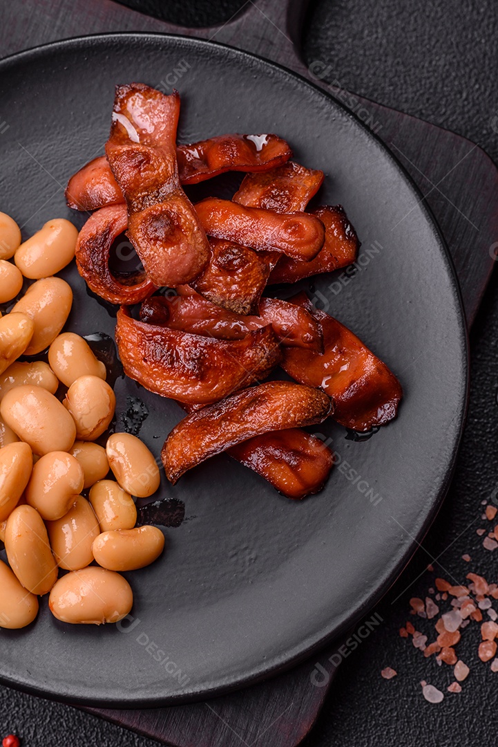 Delicioso feijão enlatado nutritivo com tomate, com sal e temperos como complemento de alto teor calórico para o café da manhã