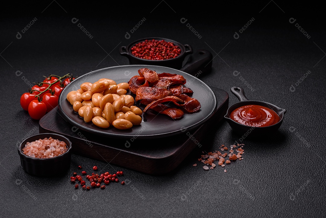 Delicioso feijão enlatado nutritivo com tomate, com sal e temperos como complemento de alto teor calórico para o café da manhã