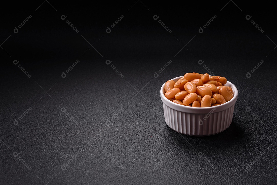 Delicioso feijão enlatado nutritivo com tomate, com sal e temperos como complemento de alto teor calórico para o café da manhã