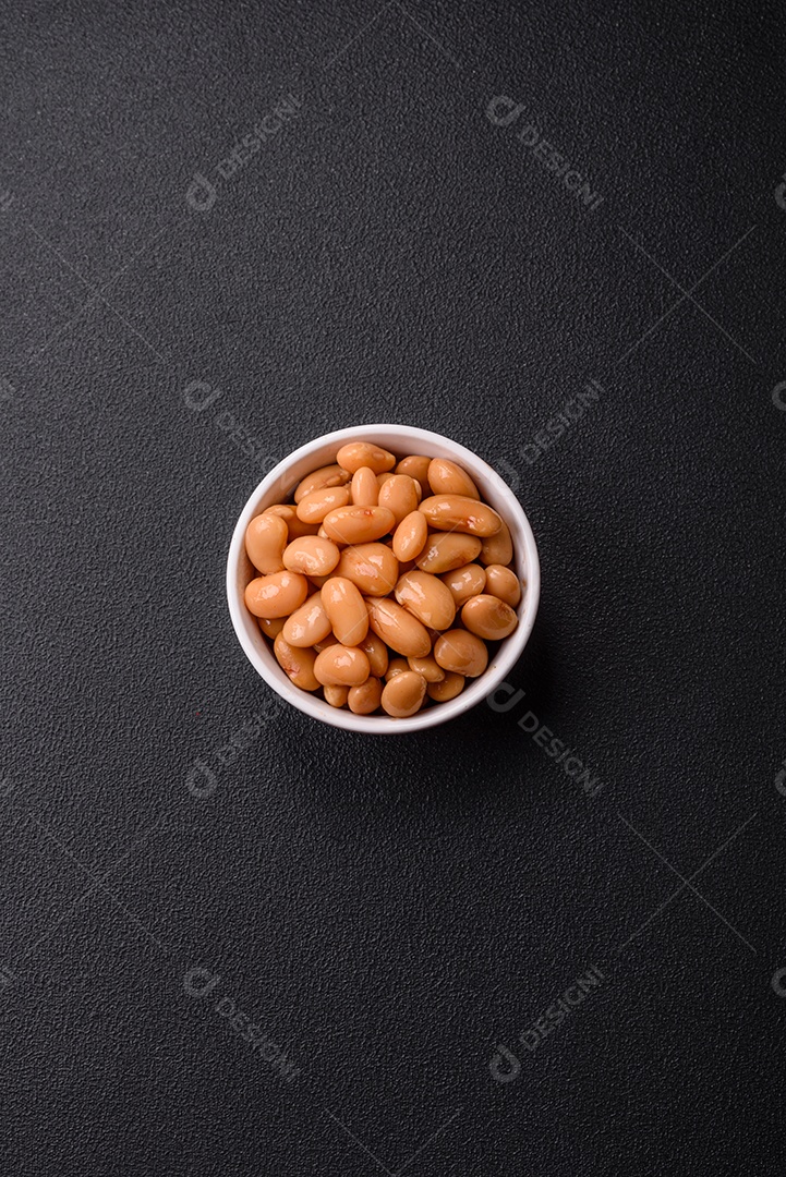 Delicioso feijão enlatado nutritivo com tomate, com sal e temperos como complemento de alto teor calórico para o café da manhã