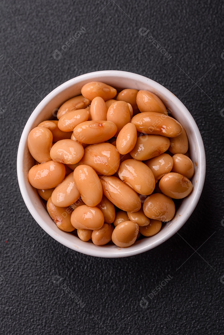 Delicioso feijão enlatado nutritivo com tomate, com sal e temperos como complemento de alto teor calórico para o café da manhã