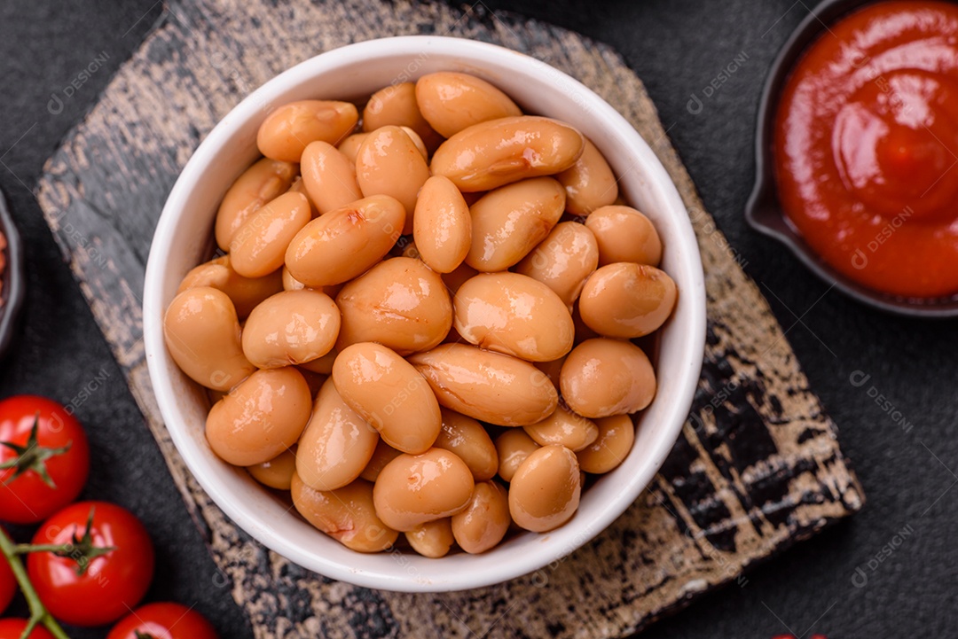 Delicioso feijão enlatado nutritivo com tomate, com sal e temperos como complemento de alto teor calórico para o café da manhã