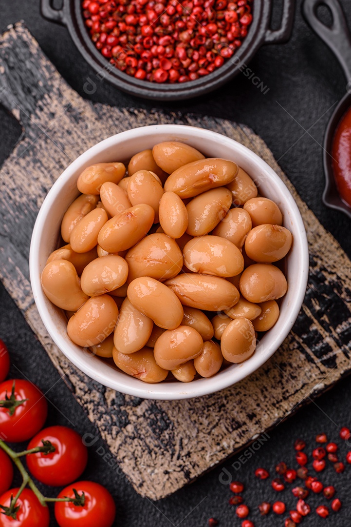 Delicioso feijão enlatado nutritivo com tomate, com sal e temperos como complemento de alto teor calórico para o café da manhã