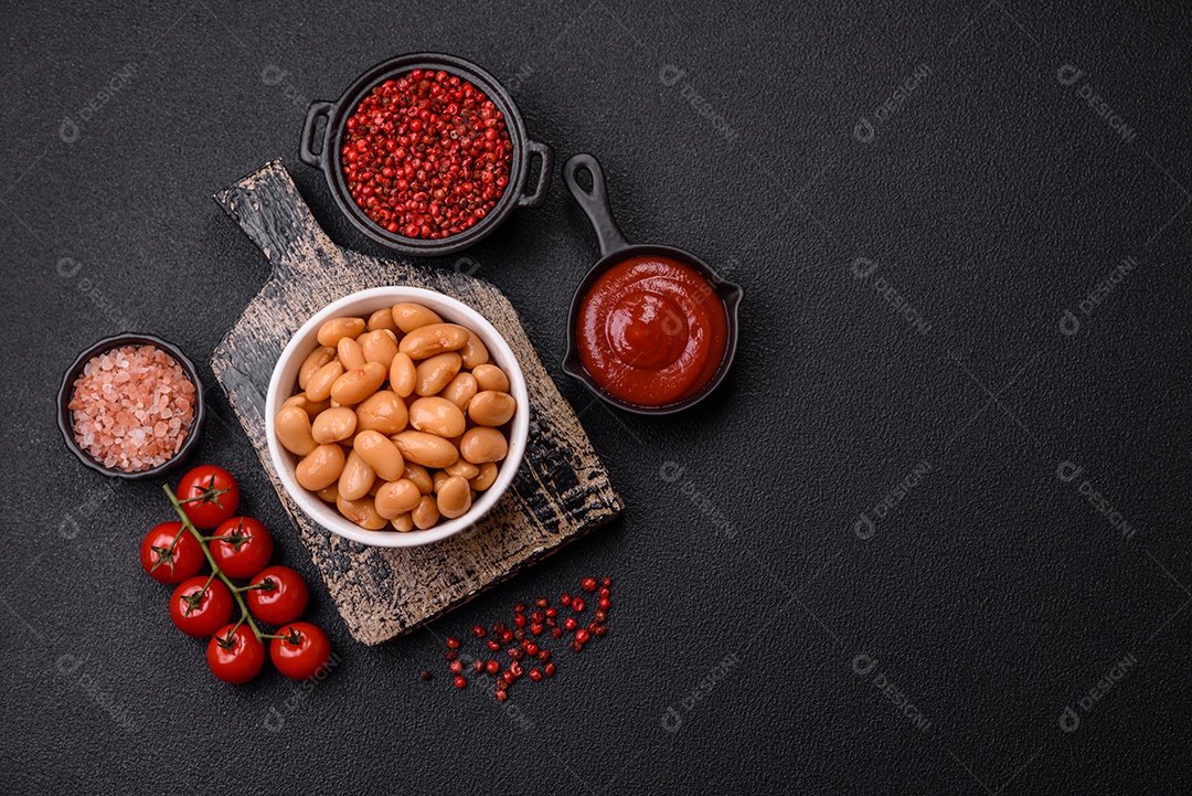 Delicioso feijão enlatado nutritivo com tomate, com sal e temperos como complemento de alto teor calórico para o café da manhã